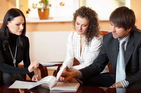 A couple reviewing paperwork with advisor.