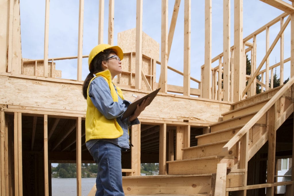 Woman at construction site reviewing plans