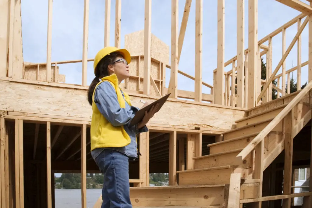 Woman at construction site reviewing plans