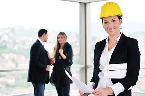 Woman architect in the forefront with couple in background.