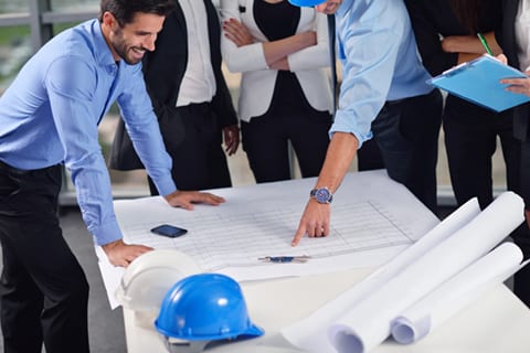 Co-workers reviewing building plans.