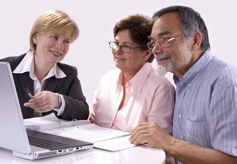 Older couple and Realtor looking at a laptop.