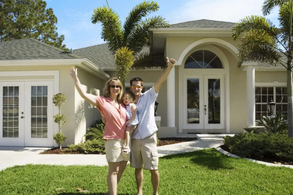 Family standing in front of their new home.