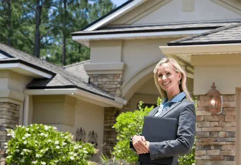 Realtor in front of a model home.